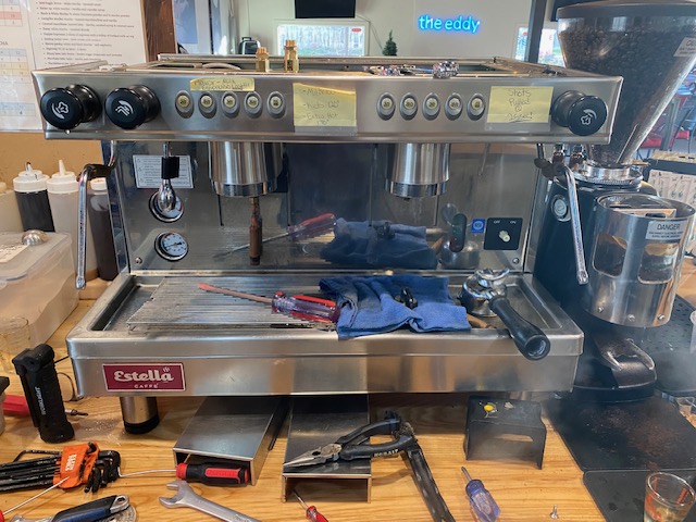 Commercial espresso machine being serviced with diagnostic tools